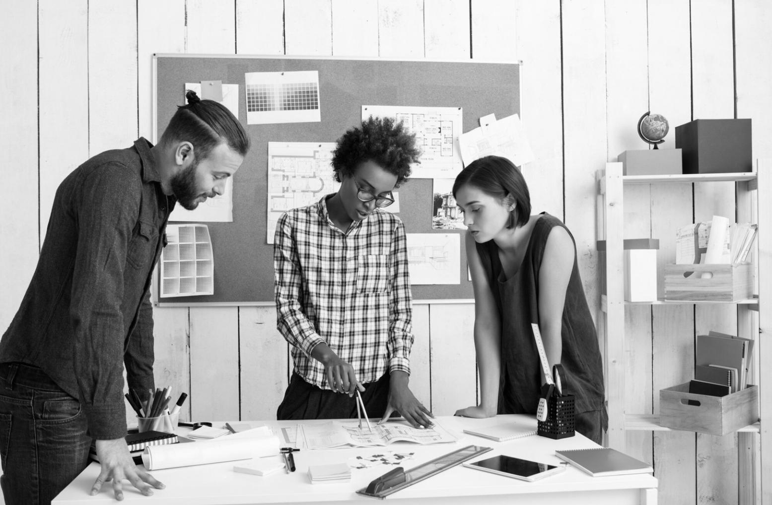 Person reviewing budget documents with calculator and laptop